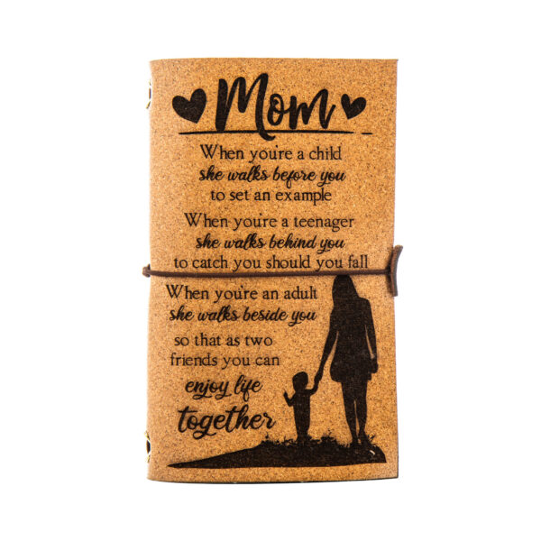 A journal with a cork cover engraved with a message for a mother and a silhouette of a mother and child.